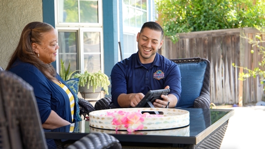 All City Plumbing tech sitting down with customer