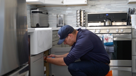 All City Plumbing tech repairing kitchen sink