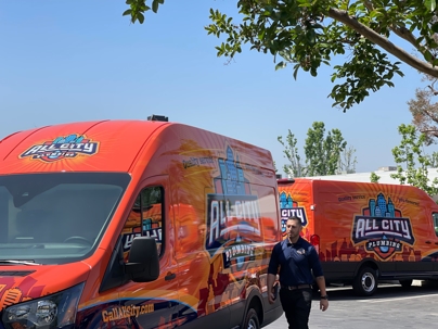 All City Plumbing vans with technician walking by