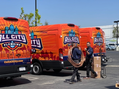 All City branded vans with two technicians in passing