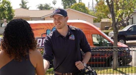 All City Plumbing tech greeting customer at front door