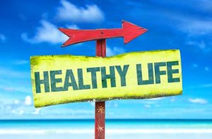 Sign on the beach pointing toward a "healthy life"