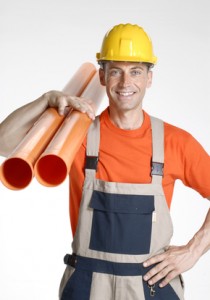 Construction worker holding pipes