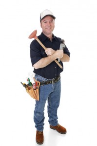 Plumber standing and holding plumbing tools