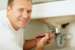 Plumber working underneath a sink