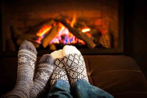 Two people's feet warming up by the fire
