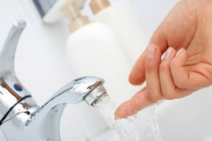 Person putting their finger under running water