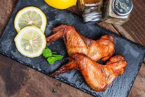 Chicken wings on a plate with lemon and spices