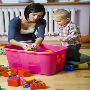 Mother supervising young son as he plays with toys