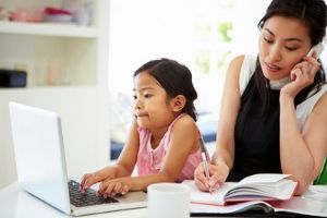 Mom on the phone while her daughter is on the computer