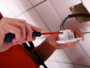 Person working on wiring in a wall